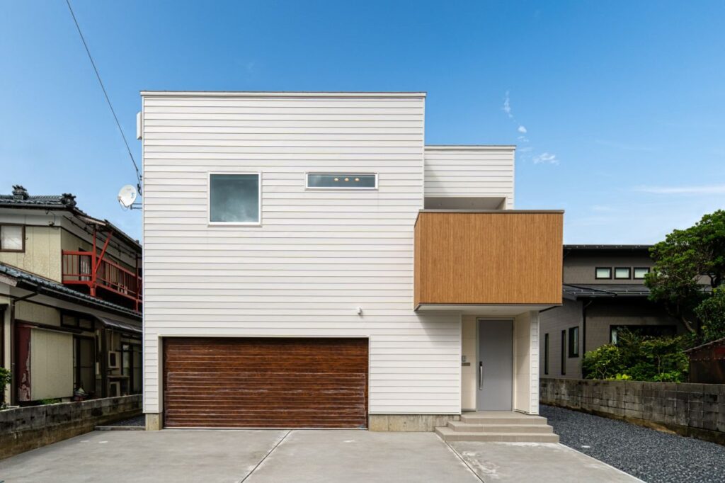 木目のガレージとテラスが映える外観