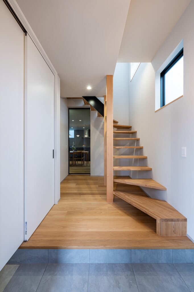 階段上からは朝日が降り注ぎ、LDKまで真っ直ぐ視線が伸びる玄関ホール