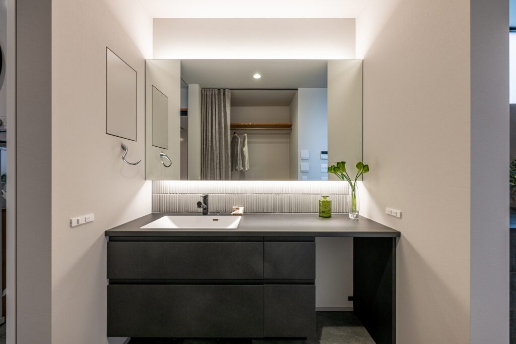 繊細な縦ラインタイルと間接照明がポイントの洗面