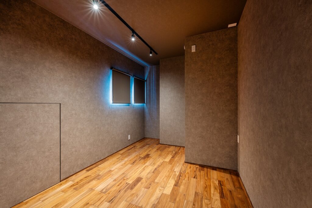 ークな趣味室。手前には小屋裏収納へ繋がる、クロス巻きの扉。