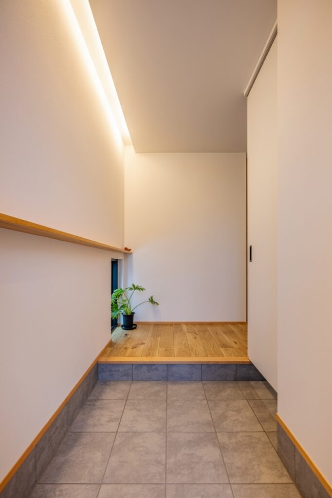 間接照明と一直線に伸びるカウンターが空間に奥行きを感じさせる玄関